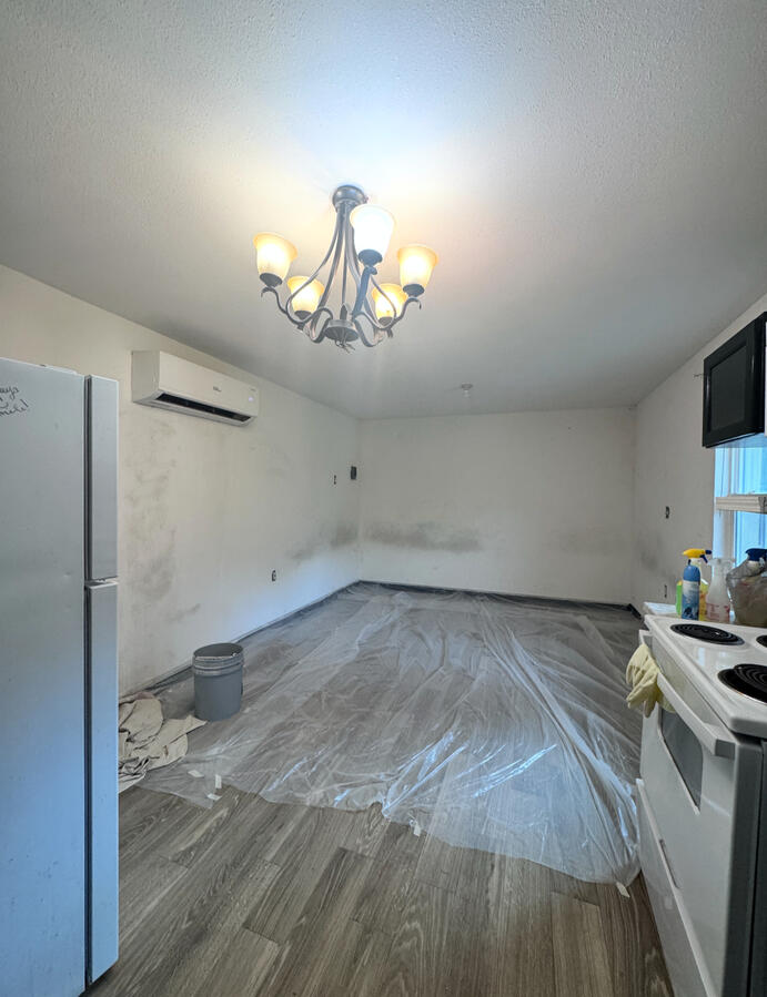 Patchy drywall, bare floors, outdated lighting
