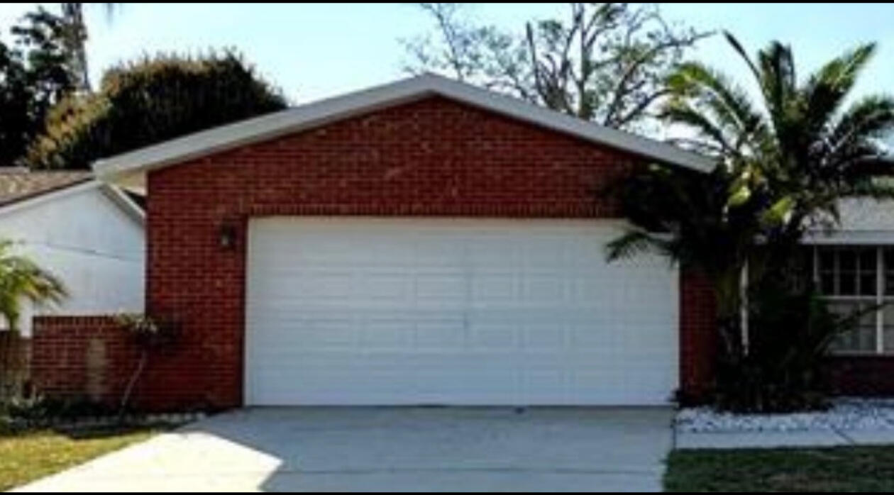 Faded red brick with generic white garage door