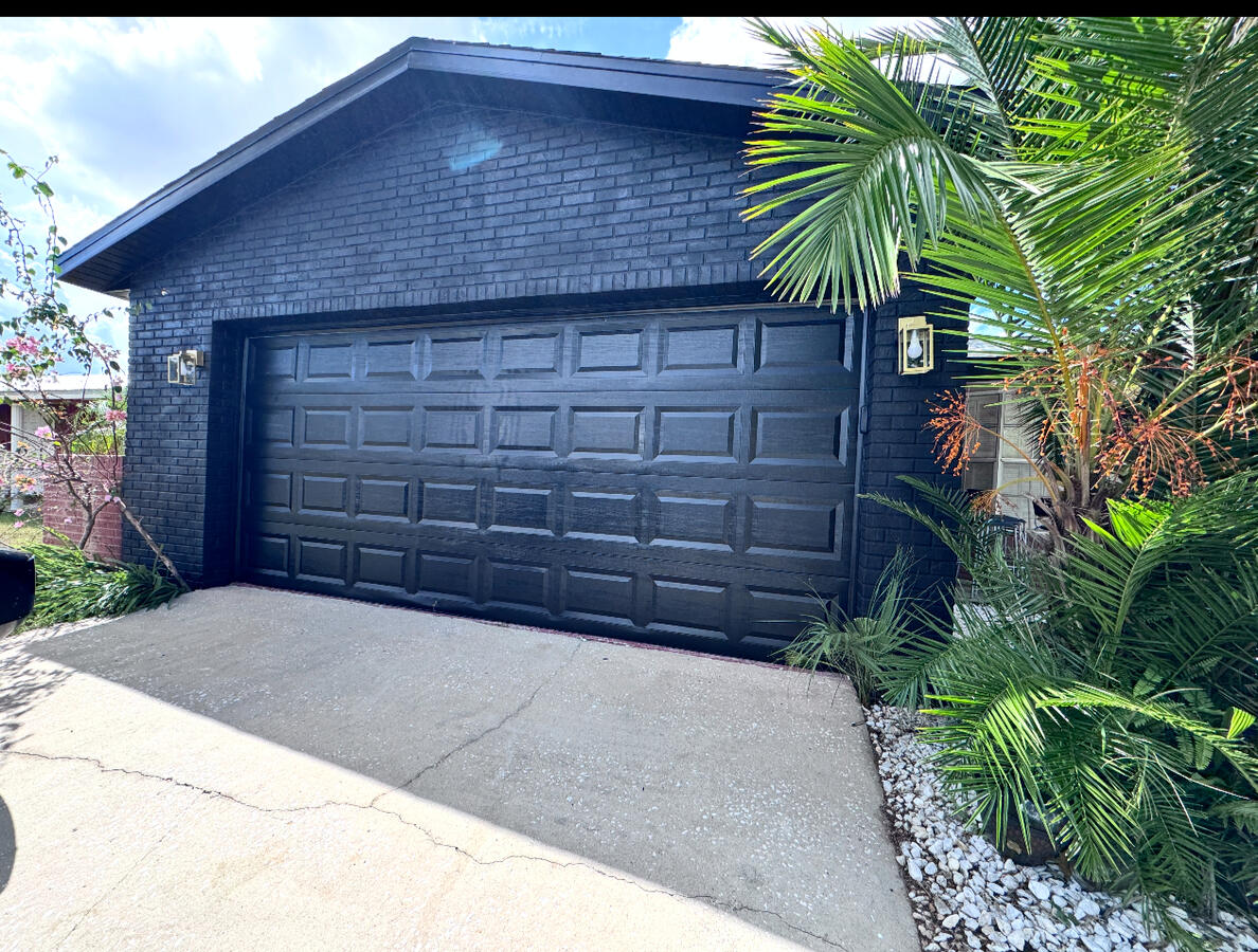 Matte black garage, deep gray brick — clean, modern curb appeal that pops